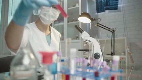 Scientist Analyzing Test Tubes in Laboratory Setting