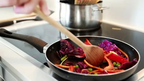 Stir Frying Colorful Vegetables in Kitchen