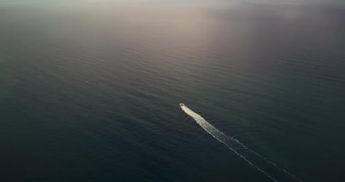 Drone Fly Over Mediterranean Sea and Motor Boat Which Going Fast on Sunset