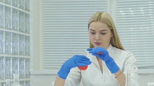 Woman Scientist Pours Liquid in Laboratory