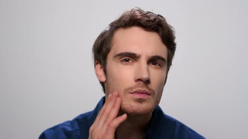 Man Checking Beard in Studio. Bearded Man Touching Face with Hand