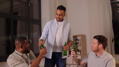 Three Men with Beer Bottles Socializing Indoors