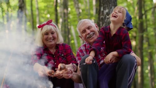Family Camping Trip in Forest Roasting Sausages