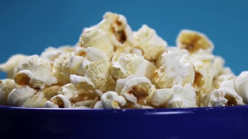 Popcorn cuit dans une assiette sur fond bleu