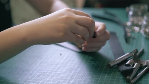 Craftsperson Attaching Buckle to a Leather Strap