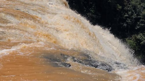 Close Up View of Dynamic Flow of Huge Waterfall with Orange Water.