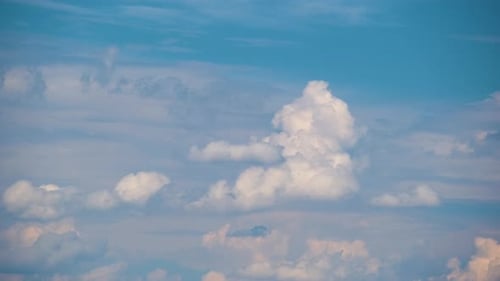 Zeitrafferaufnahmen von sich schnell bewegenden weißen, geschwollenen Cumuluswolken auf blauem, klarem Himmel
