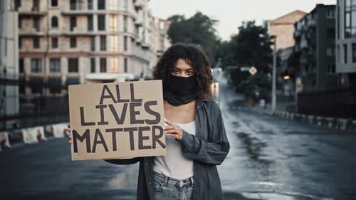 Adult Holding Sign on Empty Urban Street