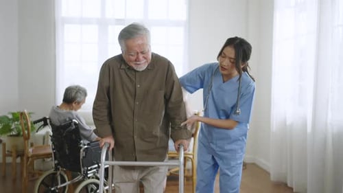 Elderly Man Walking with Assistance of Healthcare Professional