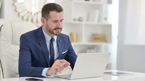Businessman Doing Video Call on Laptop in Office