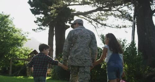 Military Man Walks with Children on Sunny Day