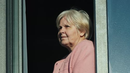 Portrait of an Elderly Woman Looking Out of the Window of Her Home
