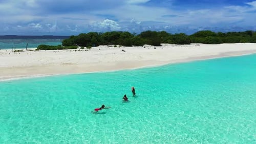 Girls tanning on tranquil lagoon beach time by transparent lagoon and white sand background of the M