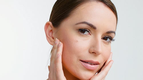 Close Up of Woman Touching Her Face and Smiling