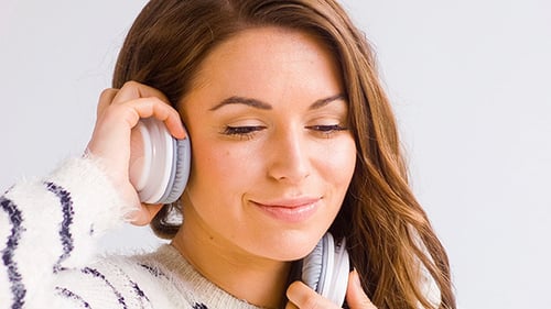 Fille souriante écouter de la musique dans ses écouteurs