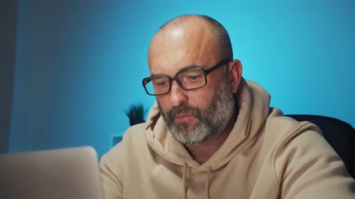Businessman Working with Laptop Computer and Papers in Office