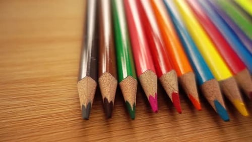 Colorful Pencils Arranged Neatly on Wood Surface