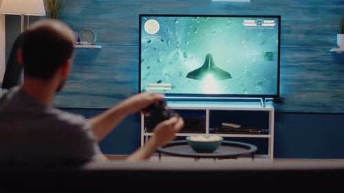 Adult Playing Space Battle Video Game at Home