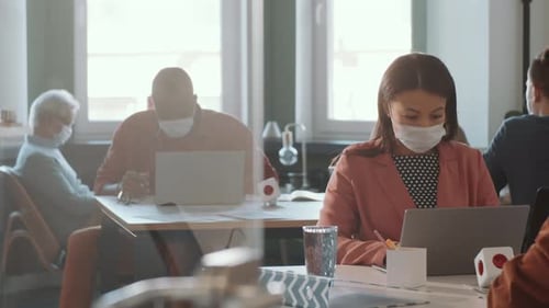 Mixed Raced Woman in Face Mask Working on Laptop in Office