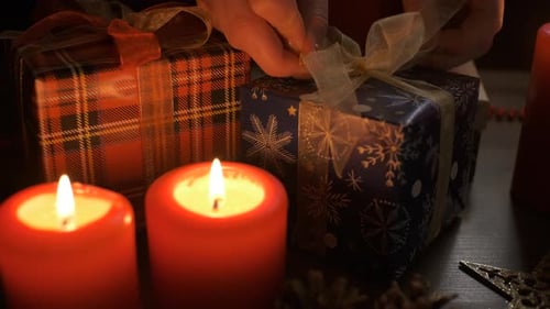 Female Hands Put and Finalize Christmas Gift on a Table Decorated