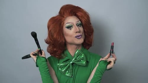 Happy drag queen having fun while doing makeup in studio