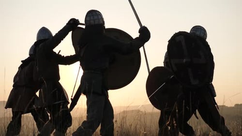 Silhouette Warriors Clash in Sunset Battle Reenactment