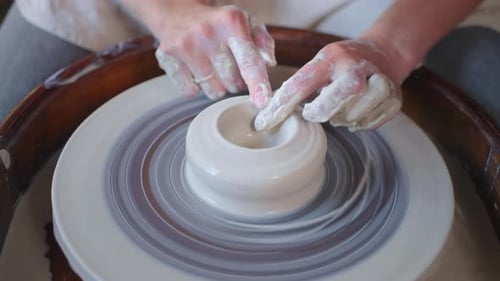 Hands Sculpting Pottery on Rotating Wheel