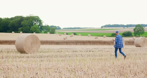 Farmer Using Digital Tablet While Examining Field