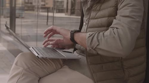 Unerkennbarer Geschäftsmann, der im Freien am Laptop arbeitet