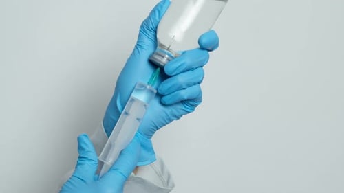 Medical Professional Drawing Liquid into Syringe