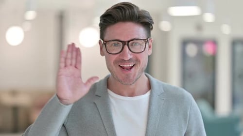 Porträt eines fröhlichen Mannes mittleren Alters, der der Kamera zuwinkt