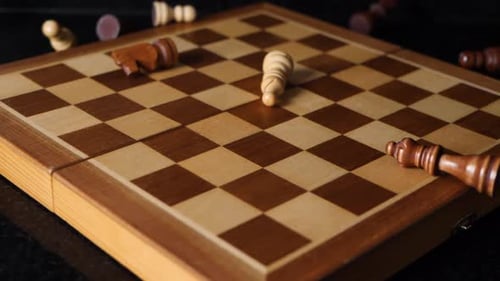 Chess figures dropping on a chess board in slow motion.