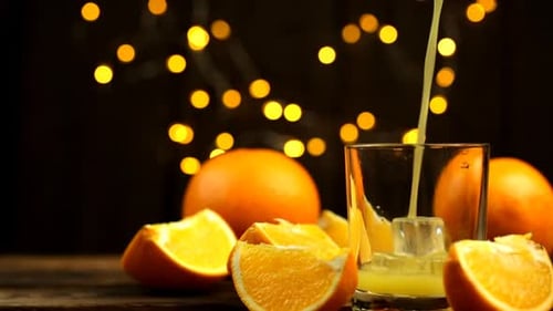 Pouring Fresh Orange Juice with Bokeh Lights