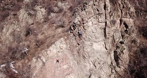 Climber climbs the rock. Girl and boy climb the rock. Rock climbing lessons. Rocky cliff