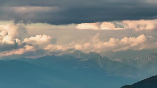 Clouds Moving over Alpine Mountains in Sunny Summer Evening