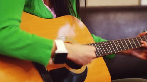 Young Adult Plays Acoustic Guitar Indoors