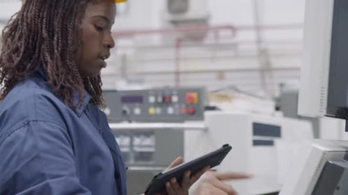 Focused African American Female Factory Worker Testing Machine