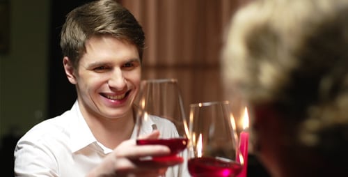 Man Drinking Wine During a Candlelit Dinner