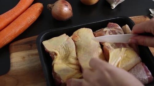 Woman's hands skin fresh chicken pieces close up