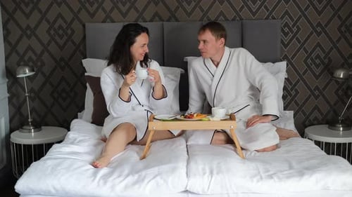 Romántica pareja caucásica desayunando en la cama