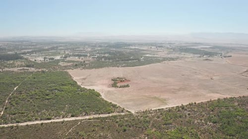 Flying Over a Plain and a View of the Landscape Under a Clear Blue Sky