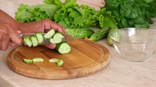 Hands Slicing Fresh Cucumber for Healthy Salad