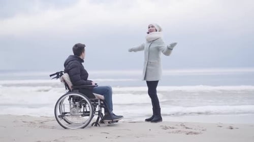 Man in Wheelchair with Friend on Beach