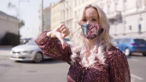 Woman With Mask Gives Thumbs Down in City