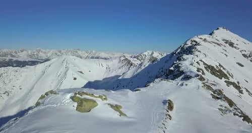 Aerial drone view of snow covered mountains in the winter.