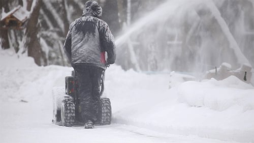 Man Operating a Snowblower on a Snowy Day