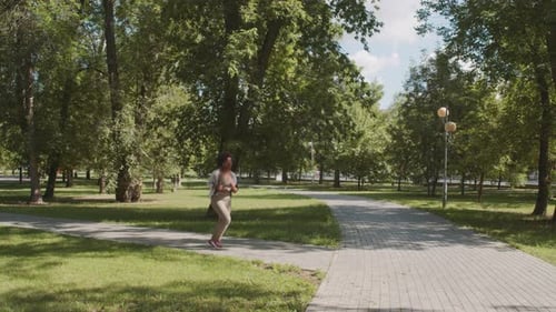 Woman Jogging in Park on Sunny Day