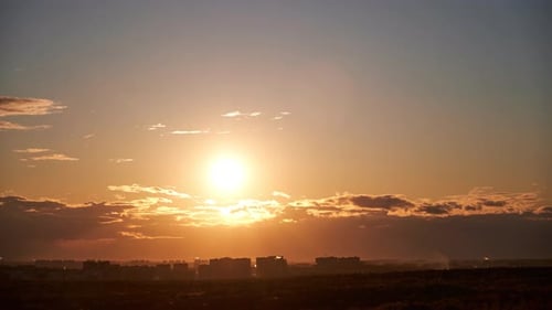 Sunset among the evening clouds. Red sun in the evening sky, timelapse