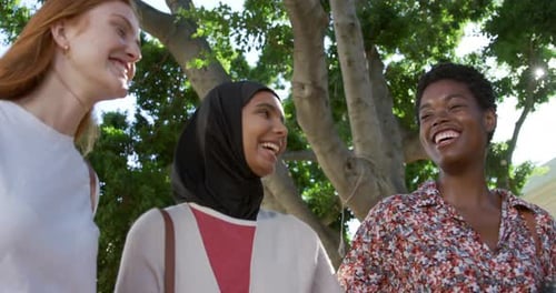 Three Friends Laughing Together in City Park