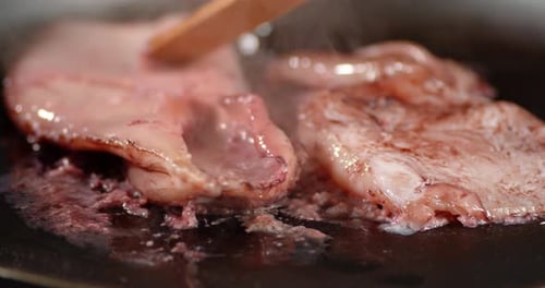 Squid Cooking in Pan with Wooden Tongs